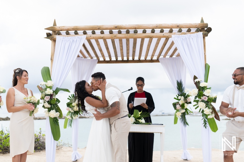 Couple exchanges vows in a romantic wedding ceremony at Sunscape Curacao Resort on the beach with a serene ocean backdrop