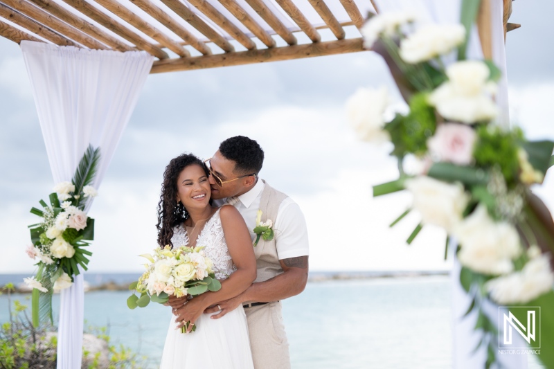 Couple shares a romantic moment during their wedding at Sunscape Curaçao Resort with beautiful floral decorations