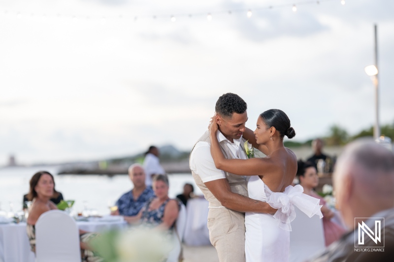 Couple shares a romantic dance at their wedding celebration on the beach in Curacao at Sunscape Curaçao Resort during sunset