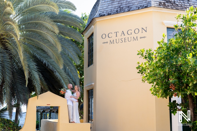 Couple shares a romantic moment outside the Octagon Museum during their wedding celebration at Avila Beach Hotel in Curacao at sunset