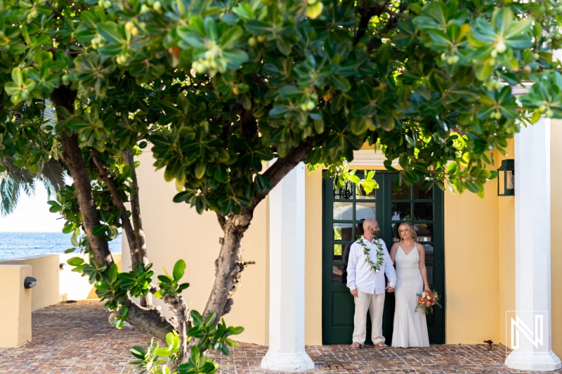 Couple sharing a romantic moment at sunset outside Avila Beach Hotel in Curacao during their wedding ceremony
