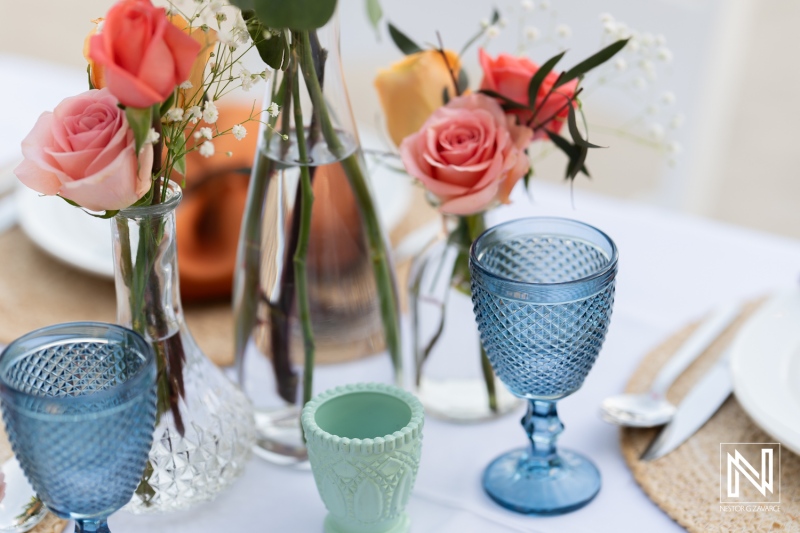 Wedding celebration at Avila Beach Hotel in Curacao featuring elegant floral arrangements and decorative glassware during sunset