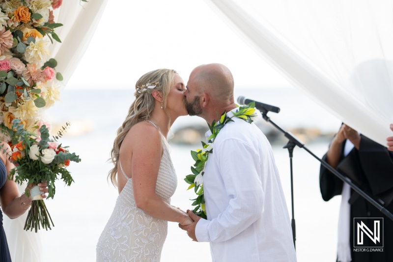 Couple exchanges vows and kisses during romantic sunset wedding ceremony at Avila Beach Hotel, Curacao