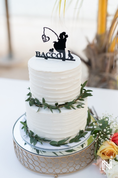 Celebratory wedding cake adorned with fishing theme at Avila Beach Hotel during sunset in Curacao