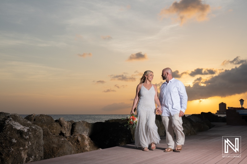 Couple enjoying a romantic sunset stroll at Avila Beach Hotel in Curacao during their wedding celebration