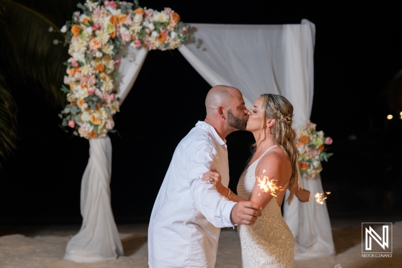 Celebrating love at Avila Beach Hotel in Curacao as a couple kisses under sparkling lights during sunset