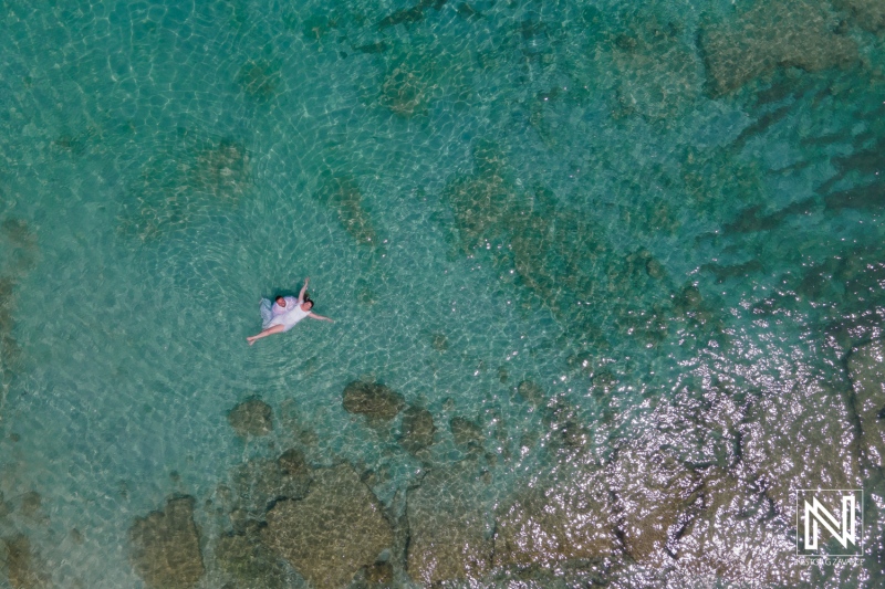 A Person Floating Serenely in Crystal-Clear Turquoise Waters off a Tropical Coastline During a Sunny Day