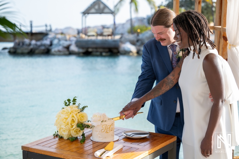 Couple celebrates their wedding at Baoase Luxury Resort with a beautiful cake cutting by the ocean
