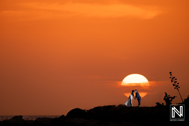 Couple embraces during sunset at Baoase Luxury Resort in Curacao, capturing a moment of love and celebration