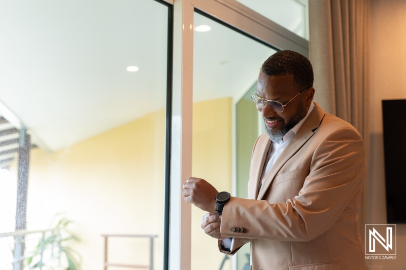 Groom adjusting his watch before destination wedding at Avila Beach Hotel in Curacao