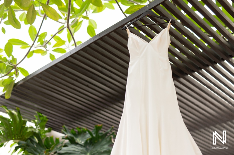 Elegant wedding dress hanging at Avila Beach Hotel in Curacao before a tropical destination wedding