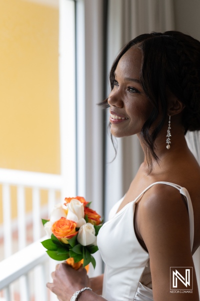 Bride in elegant wedding dress prepares for ceremony at Avila Beach Hotel in Curacao surrounded by beautiful flowers
