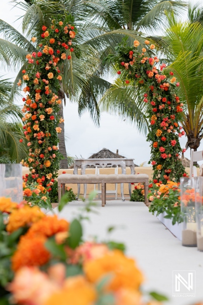 Beautiful floral arch and white aisle set for a destination wedding at Avila Beach Hotel in Curacao