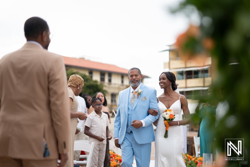 Wedding ceremony at Avila Beach Hotel in Curacao with the bride and her father walking down the aisle