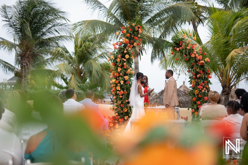 Romantic wedding ceremony at Avila Beach Hotel in Curacao surrounded by palm trees and floral decorations