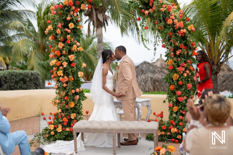Couple exchanges vows in a romantic ceremony at Avila Beach Hotel, Curacao under a floral arch