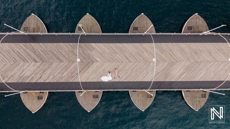 Destination wedding at Avila Beach Hotel in Curacao features bride and groom on scenic pier