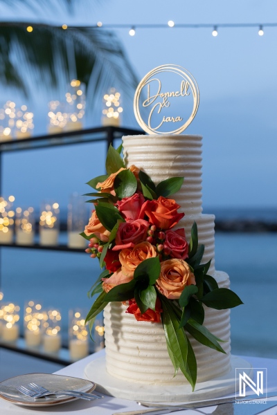 Stunning wedding cake adorned with colorful flowers at a Curacao beach venue