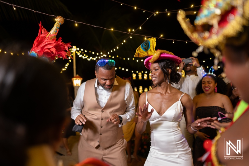 Couples celebrate joyfully during their destination wedding at Avila Beach Hotel in Curacao under enchanting lights