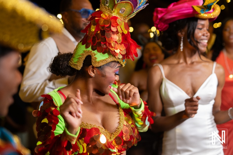Dance celebration at a colorful wedding reception in Avila Beach Hotel, Curacao, full of joy and vibrant costumes
