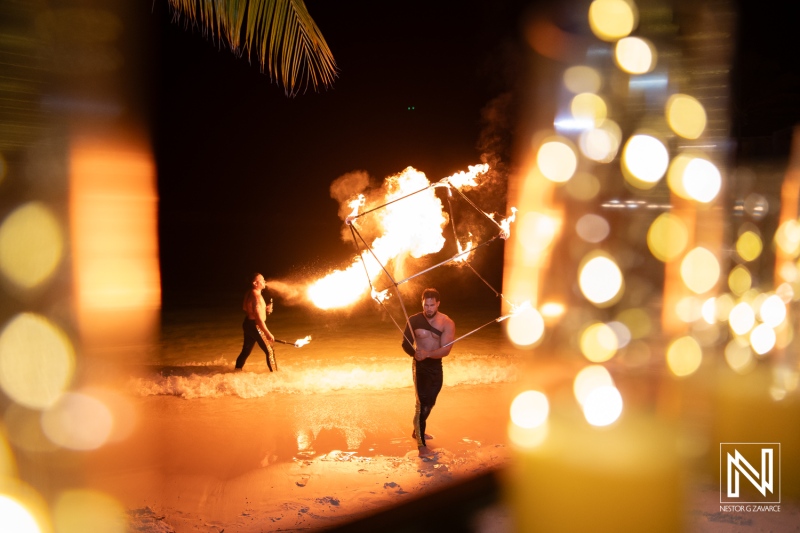 Couples celebrate their destination wedding with a stunning fire performance at Avila Beach Hotel in Curacao