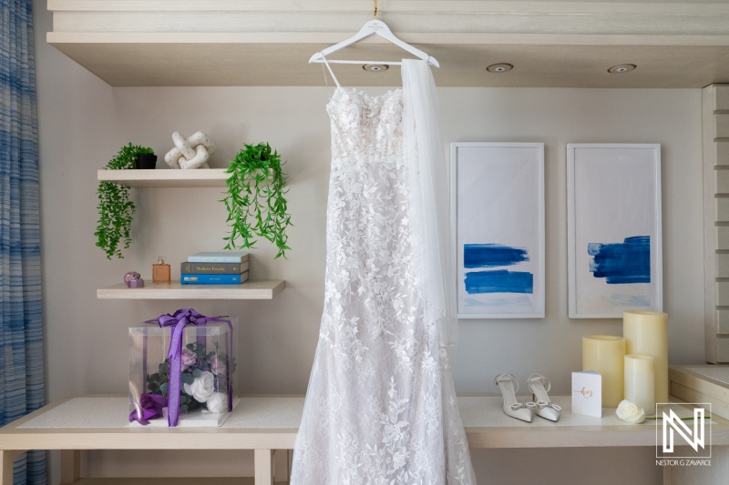 Elegant Wedding Dress Hanging in a Tastefully Arranged Bridal Suite Adorned With Greenery and Decorative Items During Daylight