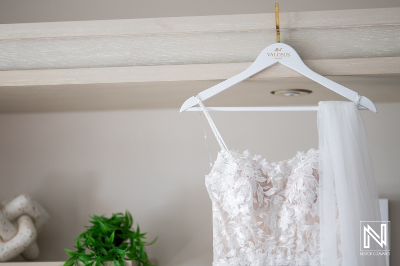 A Delicate Bridal Gown Adorned With Floral Accents, Elegantly Displayed on a Hanger Against a Soft, Neutral Backdrop in a Stylish Preparation Room