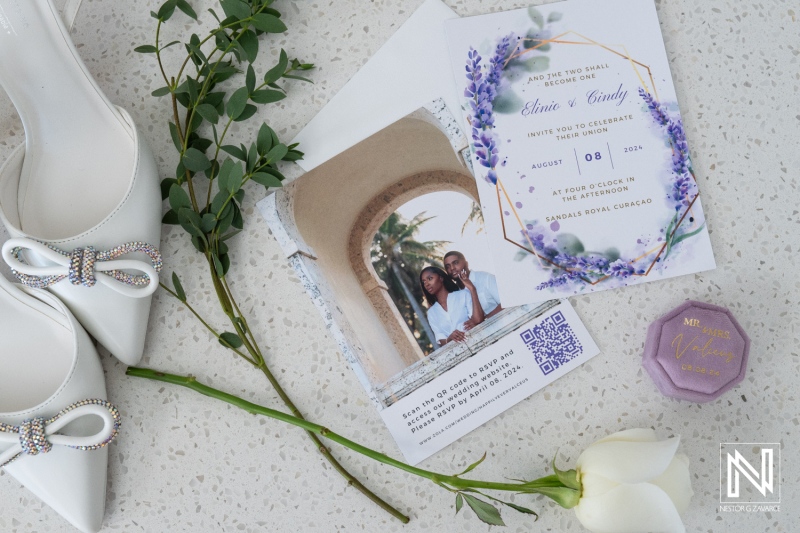 Elegant Wedding Invitation Featuring Floral Design Alongside White Heels, Greenery, and a Sweet Treat, Set in a Light-Filled Space