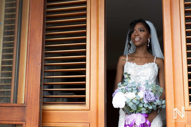 A Bride Standing Gracefully at an Open Window, Adorned in a Beautiful Lace Wedding Gown, Holding a Colorful Bouquet While Preparing for the Ceremony in a Sunny Location