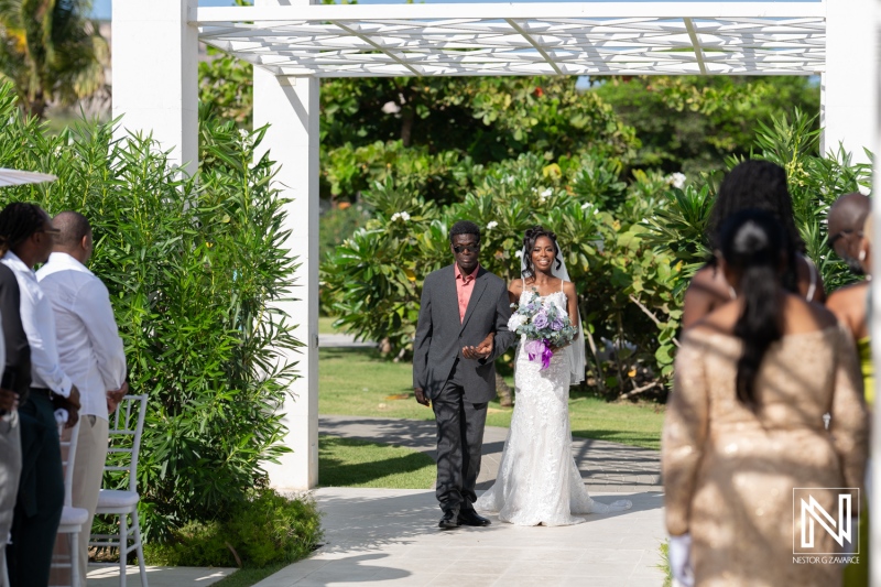 Bride Walks Down the Aisle With Her Father in a Beautiful Outdoor Wedding Setting Surrounded by Greenery