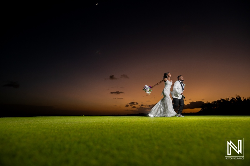 A Newlywed Couple Walks Hand in Hand on a Golf Course at Sunset, Capturing a Beautiful Moment Filled With Joy and Love