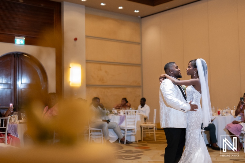 A Newlywed Couple Shares Their First Dance at a Stylish Wedding Reception in an Elegant Venue, Surrounded by Friends and Family Celebrating Their Love