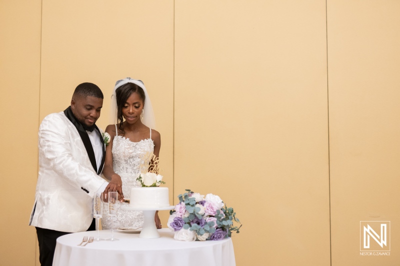 Newlyweds Cutting a Beautiful Wedding Cake Together at a Modern Celebration Venue, Surrounded by Floral Decorations and Soft Lighting in a Joyful Atmosphere