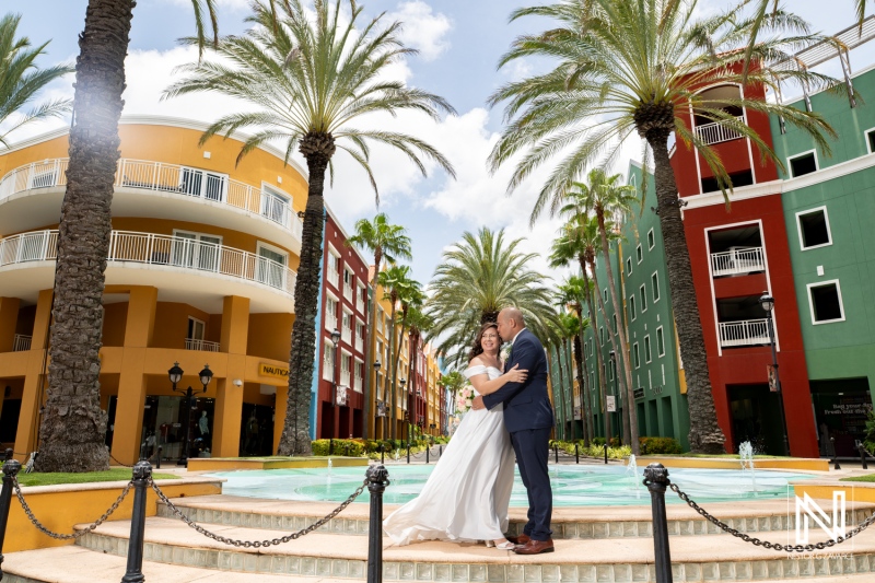 Couple shares a romantic moment by the fountain at their wedding in Kranshi, Curacao under the sunny sky
