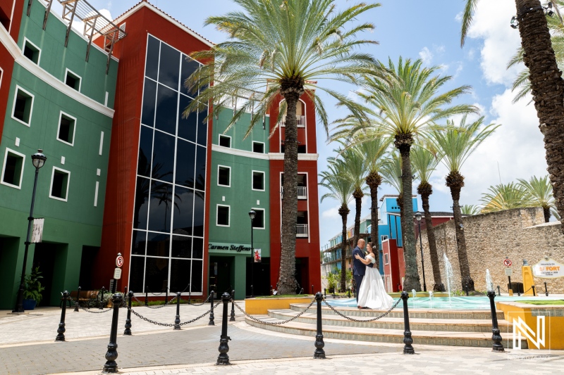 Beautiful wedding celebration at Kranshi in Curacao featuring a joyful couple amidst vibrant architecture and palm trees