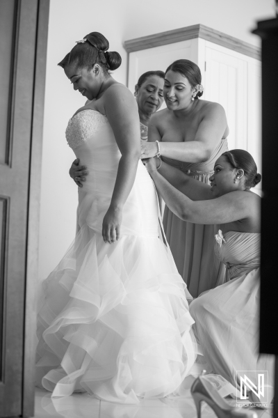 Bridesmaid hepling the bride to dress