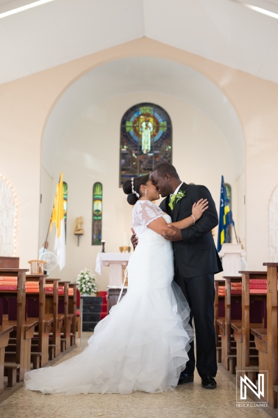 Bride and groom kissing in the church hall