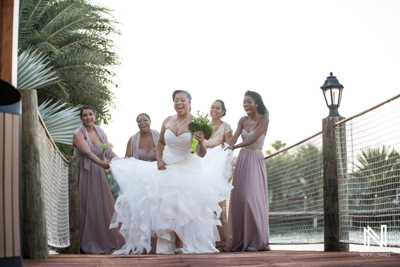 Bridesmaid holding the Bride dress on the lagoon pier