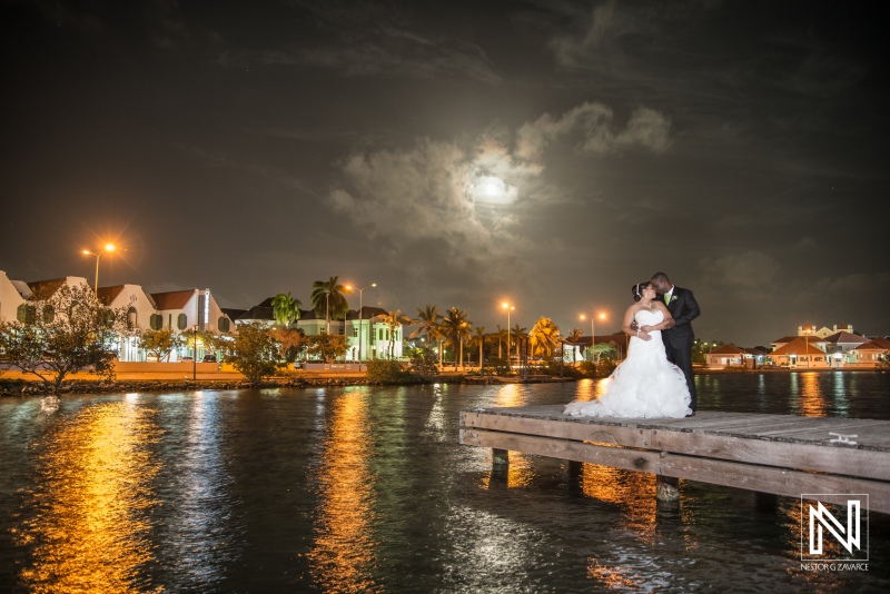 Bride and groom posing on the bay pier with the moon light