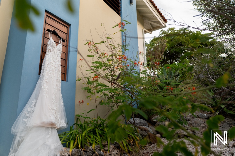 Wedding dress on display at Playa Hunku in Curacao near the venue surrounded by tropical plants