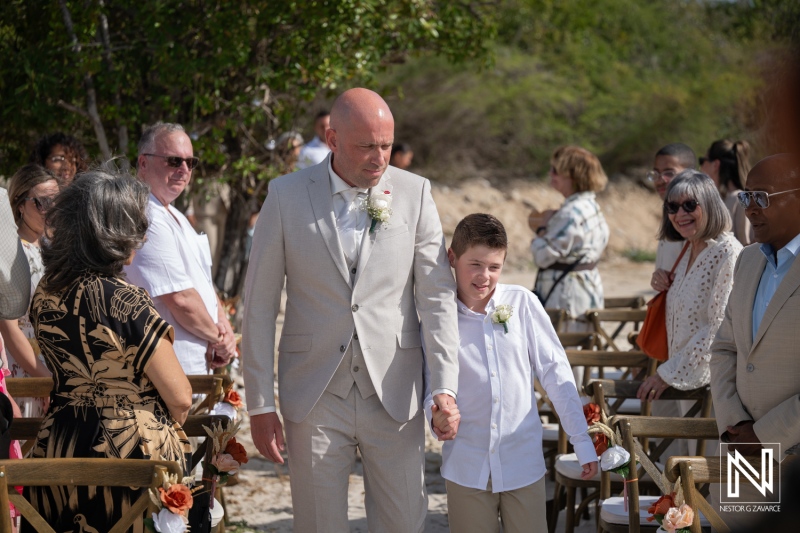 Wedding ceremony at Playa Hunku in Curacao takes place under the sun with guests sitting at a beach setting