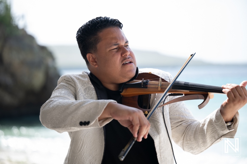 Musician plays violin at wedding ceremony at Playa Hunku in Curacao