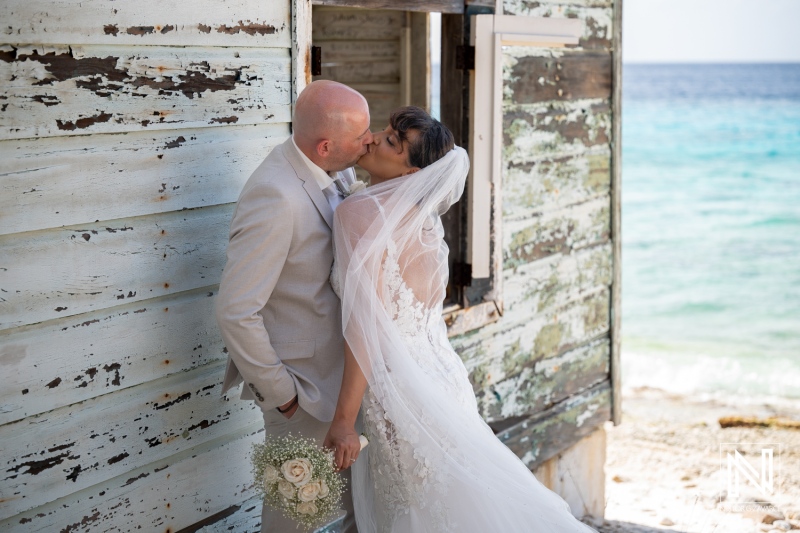 Couple shares a kiss during their wedding ceremony at Playa Hunku on the beach in Curacao
