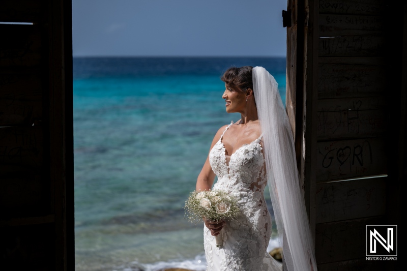 Wedding ceremony takes place at Playa Hunku in Curacao with bride holding flowers