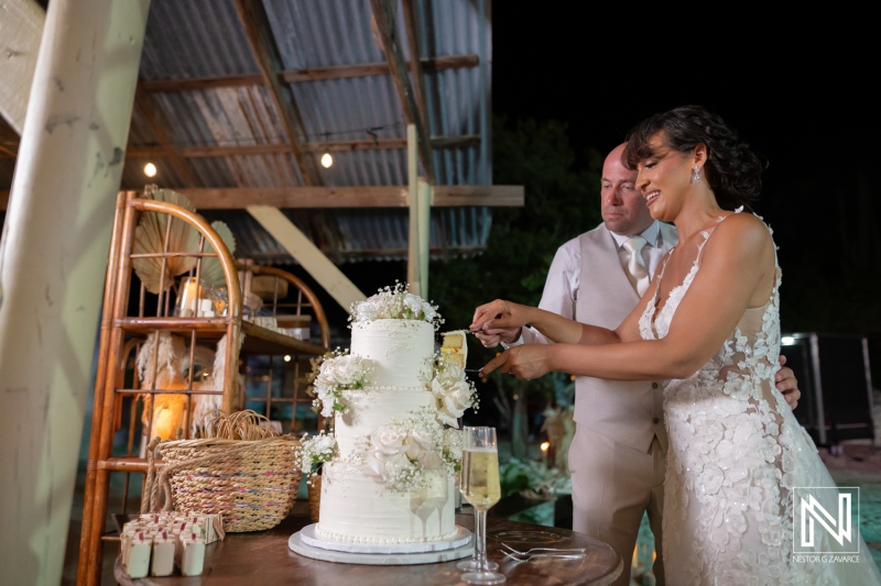 Couple cuts wedding cake at Playa Hunku in Curacao during evening celebration