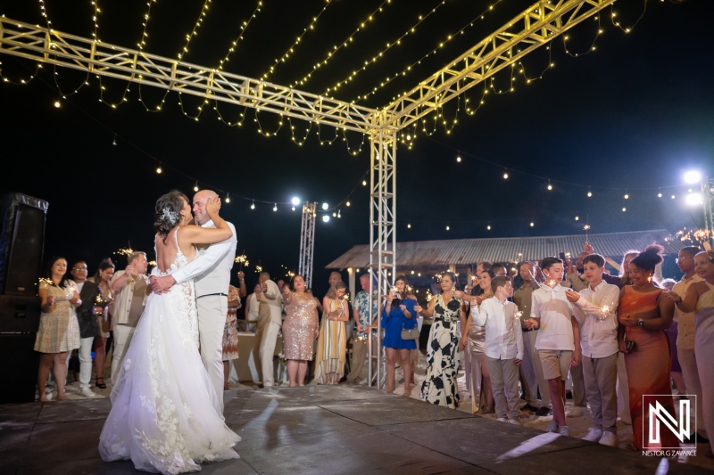 Couple dances on their wedding night at Playa Hunku in Curacao with guests celebrating around them
