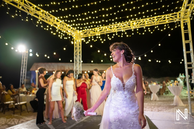 Couple celebrates their wedding at Playa Hunku in Curacao with friends and family under decorative lights