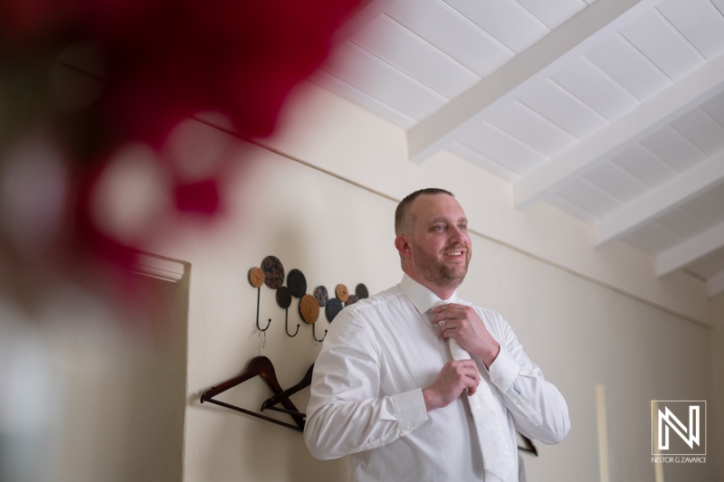 Groom preparing for his wedding celebration at Landhuis Klein Santa Martha in Curacao under bright natural light