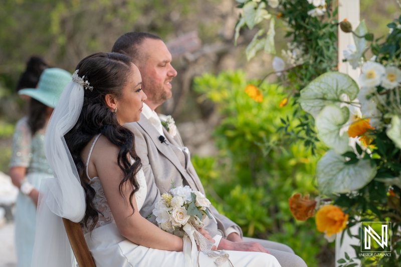 Couple shares vows during an intimate wedding ceremony at Landhuis San Nicolas in Curacao surrounded by lush tropical greenery