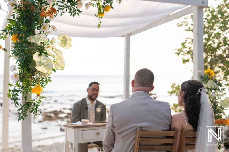 Wedding ceremony at Landhuis San Nicolas in Curacao with a couple exchanging vows by the sea
